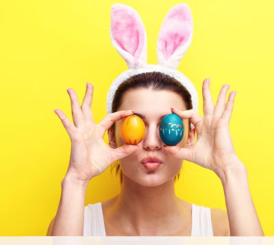 Studio shot of a happy young woman wearing bunny ears